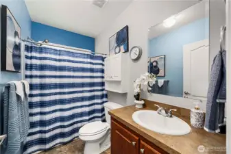 The guest bathroom features a shower/tub combo and tons of storage, offering a practical and comfortable setup for everyday use or visitors.