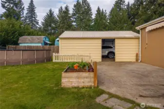 The yard connects seamlessly to the patio and carport area, keeping everything accessible while maintaining a relaxed outdoor setup.
