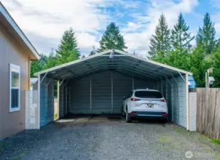A sturdy metal carport provides covered parking and everyday protection for vehicles, with easy access to the home.