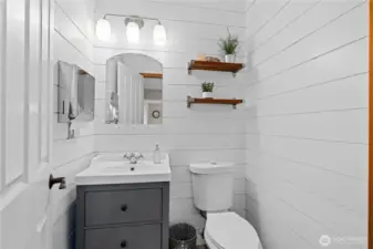 Stylish powder room offers shiplap accent walls, updated vanity, and a clean, modern look.