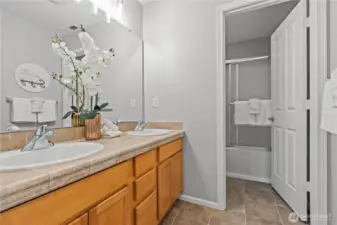 Guest bathroom with double sinks - separate toilet and tub/shower space.