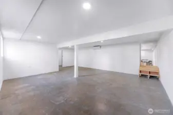 From the main side lower level entry - there is a very large living room area.  Doorway in the middle leads to a large storage and mechanical room for the home.  Stairs lead to the rest of the lower level.  To the left of stairs is the staircase that leads to the upper level.