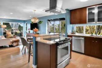 Social kitchen design includes an outward-facing island cooktop with breakfast bar.