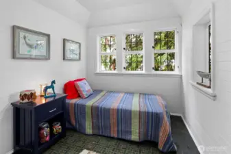 This bedroom features a spacious play area, a cutout with French doors leading to a sleeping nook, and an en suite bathroom for convenience and privacy.