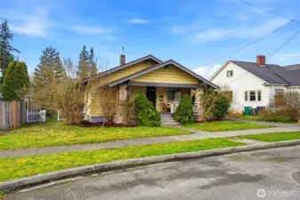 This charming bungalow features a welcoming covered front porch and classic architectural lines situated on a double lot with mature landscaping.