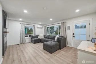 Enter into living room with tons of windows. New flooring, paint, lighting, windows and electric fireplace.