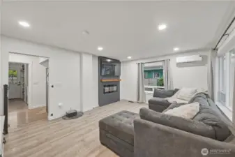 Living room looking into back hall which leads to kitchen dining area to right, laundry/mudroom straight ahead and secondary bed and bath to the left.