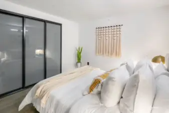 Primary bedroom with frosted glass sliding closet doors and built-ins