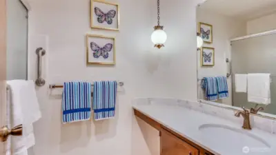 Bright bathroom featuring a large mirrored wall, enhancing the space with natural light.