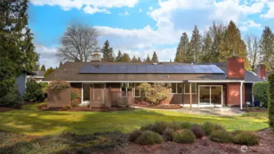 Stunning view looking to the back of the home showcasing the lush greenscape and expansive stamped concrete patio.