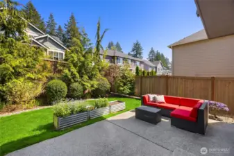 The backyard is fenced with nice grassy play space and sunny garden beds.