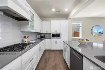 Built in gas range & microwave. With luxury boxed in hood vent and shadow box cabinets.