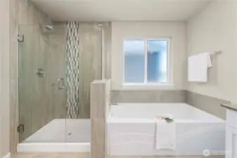 Walk in shower with tile surround and large spa tub off of shower.