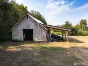 Lean-to off side offers additional covered storage for tractors and implements.