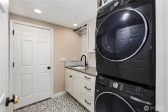 Laundry room with sink and storage space.