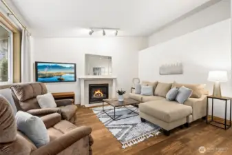 Family room has a gas fireplace, vaulted ceilings and a display ledge.