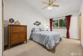 Large primary bedroom with attached 3/4 bath, large walk-in closet and ceiling fan.