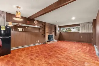 Downstairs rec room offers great ceilling height and a groovy vibe.  Daylight basement with lots of window light and wood insert fireplace.