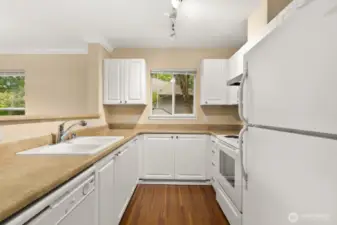 Kitchen features white cabinetry and appliances for a cohesive style.