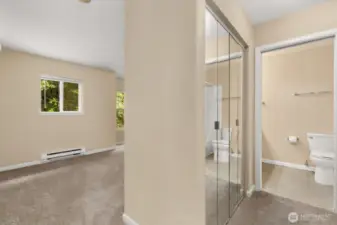 View of primary, looking down to private ensuite. This bedroom offers closet (shown) and a large walk-in closet across the hall.