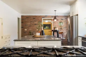 The chef’s kitchen is a showstopper, featuring granite counters, a premium gas range, and an oversized walk-in pantry—perfect for entertaining or farm-to-table cooking using your own fresh-picked produce from established fruit trees, berries, grapevines, and raised garden beds.