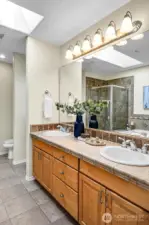 The built-in bench is in the nook just to the left of this grand double-vanity.