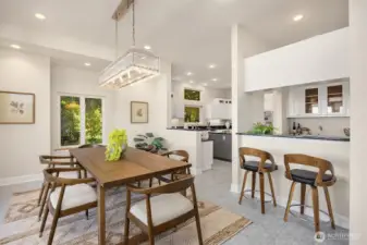 Dining area with statement lighting opens to the kitchen and wet bar, offering functional flow for daily living and entertaining.