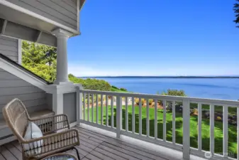 Private deck off the primary bedroom with elevated water views overlooking the lawn and shoreline.