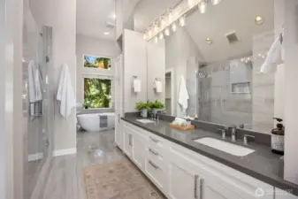 Spacious primary bathroom with double vanity, walk-in glass shower, and soaking tub, finished with modern tile and updated fixtures.
