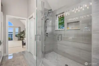 Walk-in glass shower with full-height tile surround, built-in niche, and updated fixtures, creating a clean and modern finish.