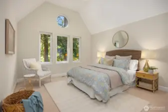 Spacious upstairs bedroom with vaulted ceilings and multiple windows for natural light.