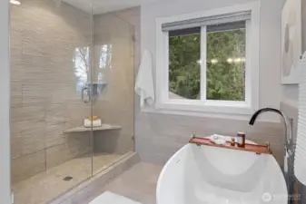 Shower is tiled floor to ceiling with modern soaking tub