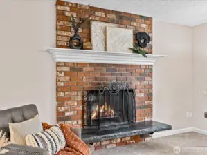 A classic brick fireplace anchors the living room — the perfect place to gather on cool Northwest evenings.