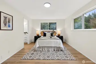 Straight-on view of the primary highlights the treed outlook, en suite access, and clean lines that make this a true retreat.