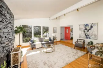 Soaring ceilings and expansive windows define the living room, drawing in natural light and reinforcing a sense of openness.