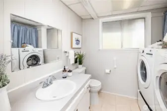 A combined bathroom and laundry area serves the lower level with practical efficiency, supporting both daily living and guest use.