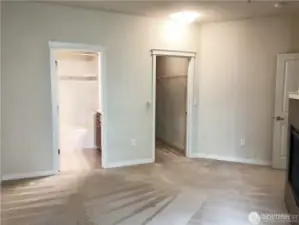 Another view of the primary bedroom - bathroom on left, walk-in closet on right.