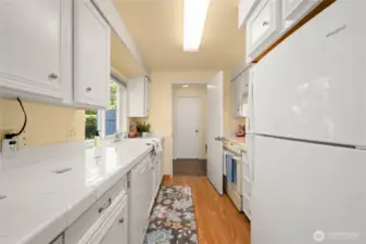 A kitchen with great counter space. The utility room is beyond the kitchen.  Access the garage or the main floor half bath from the utility room.