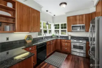 Impressive kitchen with real cherry wood cabinets, ample storage, and slab granite countertops.