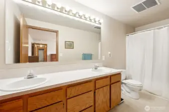 In the primary suite, double sinks for superior elbow room, oak cabinets keep your beauty stash organized, and vinyl floors are as practical as they are durable. Plus, the lighting above this huge mirror? Instagram-ready every day.