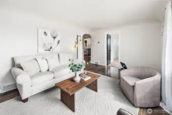 With its arched doorway, statement lighting, and neutral palette, this living room is ready for both quiet mornings and lively gatherings.