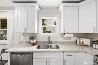 Bright white cabinetry, sleek stainless appliances, and warm wood floors make this kitchen the perfect blend of modern design and everyday comfort.
