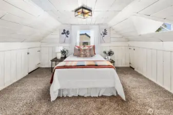 Charming upstairs bedroom with wood-paneled character, dormer windows, and plenty of natural light.