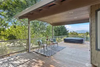 The deck, stretching the full length of the home and gracefully wrapping around the side, boasts a covered section perfect for year-round enjoyment.