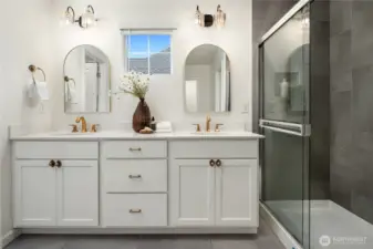 This gorgeous private bath features tiled floors, dual vanities, a linen closet, an oversized tile shower and a separate water closet.