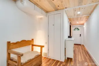 Downstairs hallway with multiple closet spaces and door to backyard patio as well as second entryway to the garage, workshop and home office space.