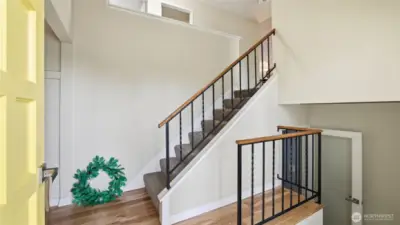 A welcoming first impression with warm hardwoods and an open staircase