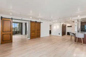 Seattle condo living area with large windows bringing in natural light, sliding barn doors, and open layout connecting the living space to the rest of the home.