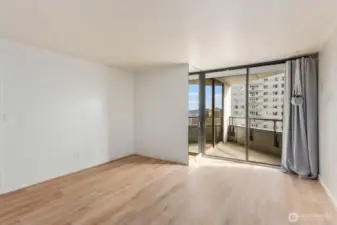 Open Seattle condo living area with large sliding glass doors, natural light, and direct access to the balcony overlooking the surrounding cityscape.