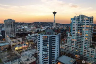 Seattle skyline aerial view featuring the Space Needle, Queen Anne hillside, and surrounding downtown neighborhoods captured during evening city lights.